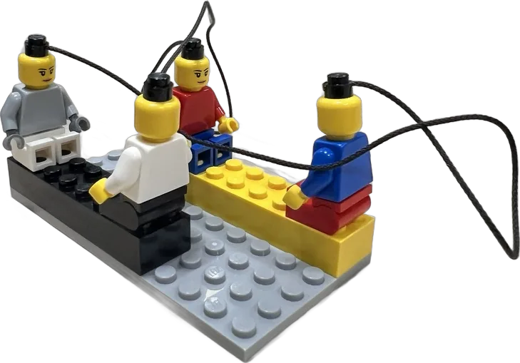 Quatre minifigurines sur un modèle, reliées entre elles par des cordelettes